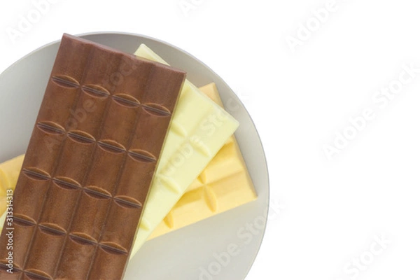 Fototapeta  tiles with milk, caramel and white chocolate on a gray plate isolate on a white background.Flat lay 