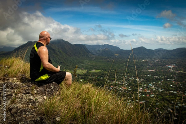 Fototapeta A Man sitting on the edge of a cliff in the Anton Valley in Panama