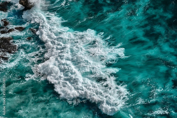 Fototapeta Aerial view to seething waves with foam. Waves of the sea meet each other during high tide and low tide.