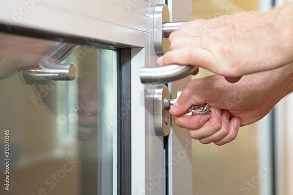 Obraz hands opening locked door  with typical key  - close up