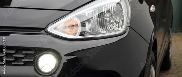 Obraz a modern car headlight with daytime running lights on a car