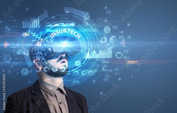Fototapeta Businessman looking through Virtual Reality glasses with INSURTECH inscription, innovative technology concept