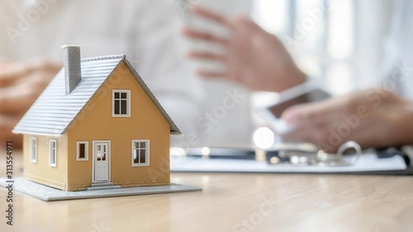 Fototapeta House model with agent and customer discussing for contract to buy, get insurance or loan real estate or property.