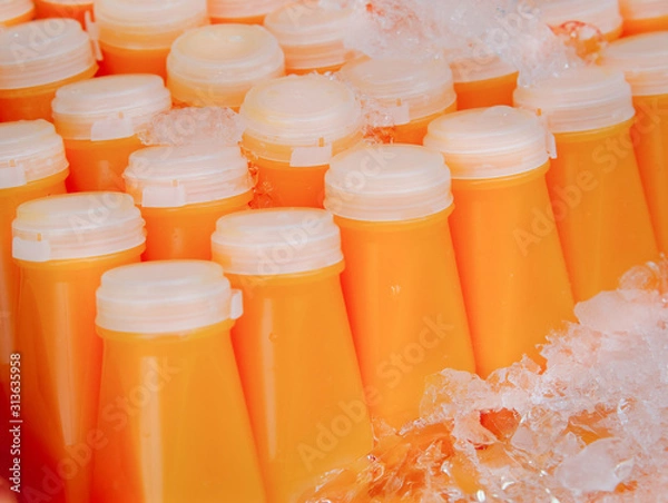 Fototapeta Fresh carrot juice or orange juice, packed in a ready-to-drink frozen plastic bottle for sale.