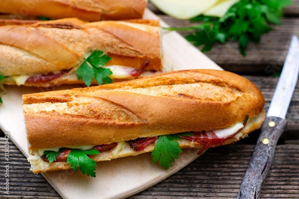 Fototapeta Oven baked baguette sandwich with cheese, ham and tomato