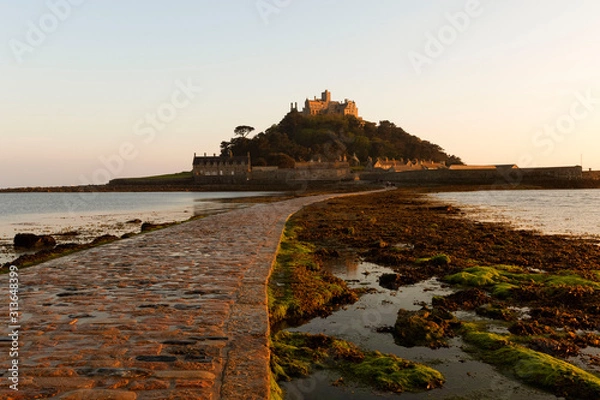 Fototapeta St Michael's Mount, Cornwall showing the causeway at low tide in golden light