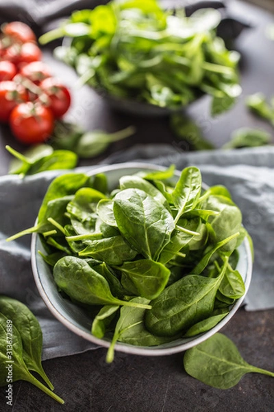 Fototapeta Fresh baby spinach in bowl on dark kitchen table