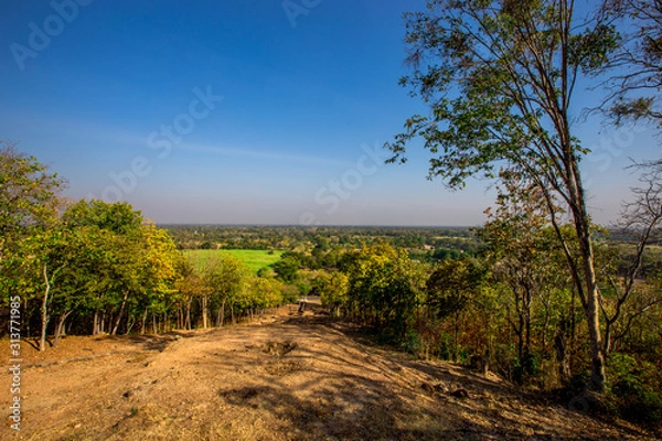 Fototapeta The blurry nature background of the Wat Saphan Hin walkway has long, stone bridges on a hill, with tourists coming to see the beauty in Sukhothai, Thailand.