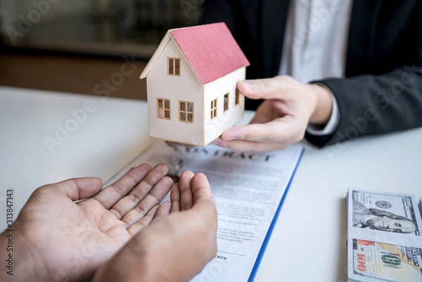 Fototapeta Real estate agent are presenting home loan and sending keys to customer after signing contract to buy house with approved property application form, Insurance Home concept
