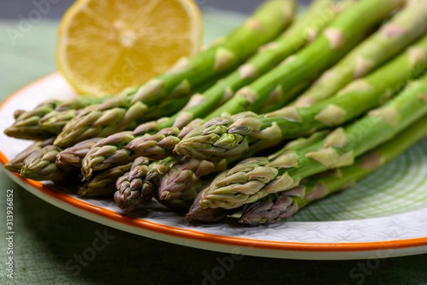 Obraz Bunch of fresh green raw organic asparagus with lemon ready to cook