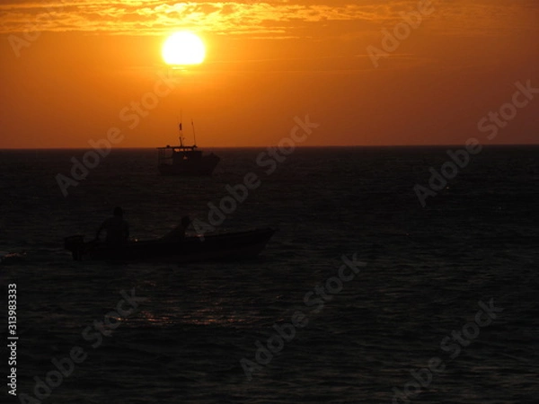 Fototapeta Fishing boat starting work at sunset.