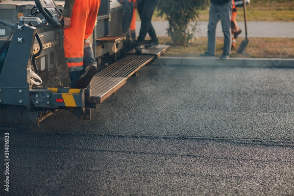 Obraz Układanie asfaltu. Maszyna do układania nawierzchni i walec drogowy. Budowa nowej drogi.