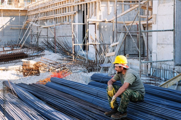 Obraz Construction worker resting on steel bars