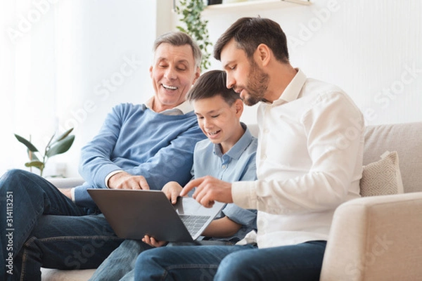 Fototapeta Father And Grandfather Teaching Boy Use Laptop Sitting On Couch
