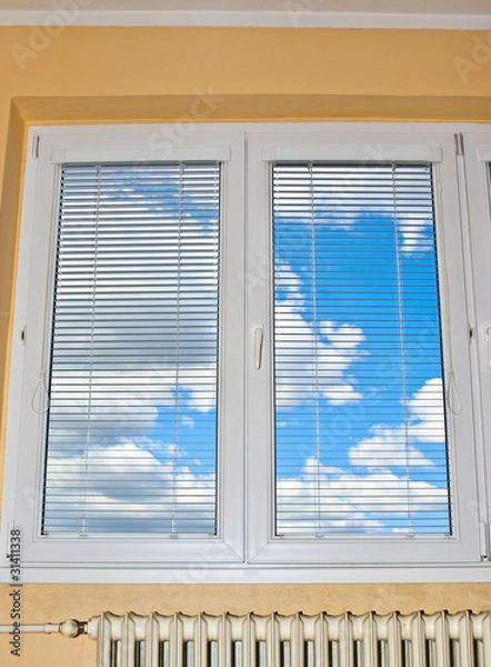 Obraz Blue sky with thick white clouds behind closed window.
