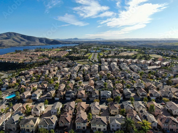 Fototapeta Aerial view of upper middle class neighborhood with identical residential subdivision houses during sunny day in Chula Vista, California, USA.
