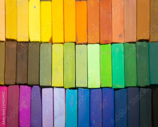 Fototapeta Used colorful pastel chalks in geometrical order. Artist supplies and accessories. Abstract horizontal background. Rainbow colors.