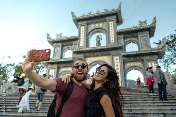 Obraz Happy tourist couple taking a selfie on a popular travel destination in Da Nang Vietnam