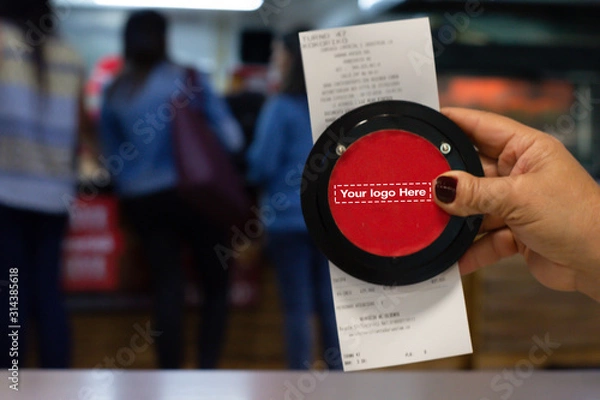 Fototapeta Hand showing Invoice with Wireless calling system restaurant or pager customers system  and person row background.