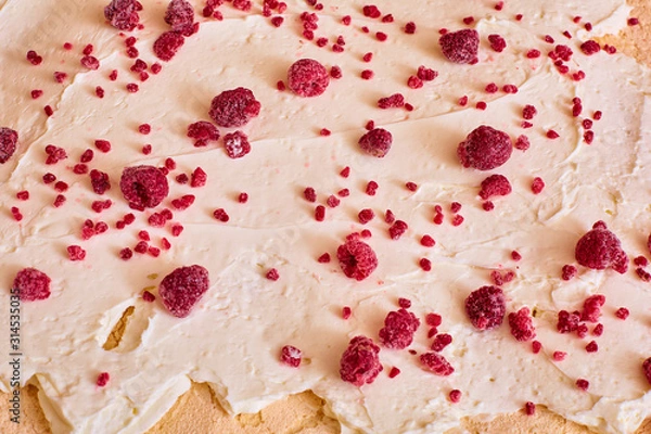 Obraz fresh raspberries are evenly distributed on a layer of butter cream for making a roll
