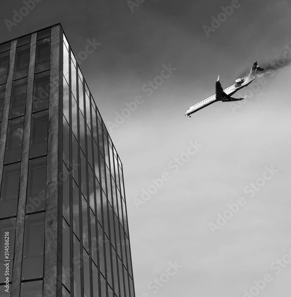 Fototapeta Airplane is flying above and has an engine fire