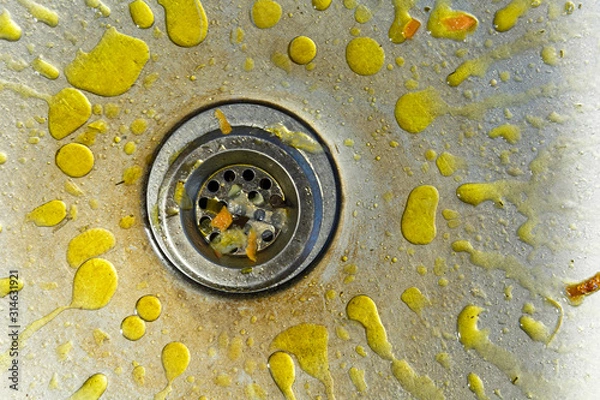 Fototapeta A dirty and littered sink with yellow grease stains.