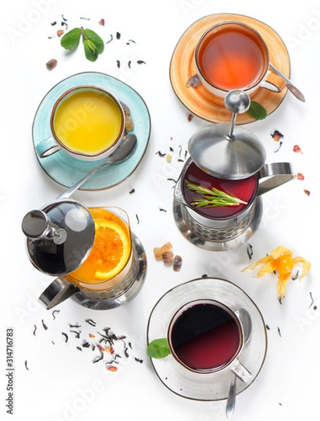 Fototapeta Hot tea, drinks in a teapot, cups with sea buckthorn, rosemary, orange, black tea. Assorted, a lot. Top view, white background.