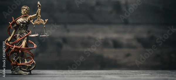 Obraz Scales of Justice, Justitia, Lady Justice and barbed wire on a black wooden background.