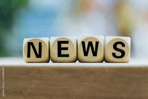 Fototapeta NEWS concept with wooden block on wooden table background.