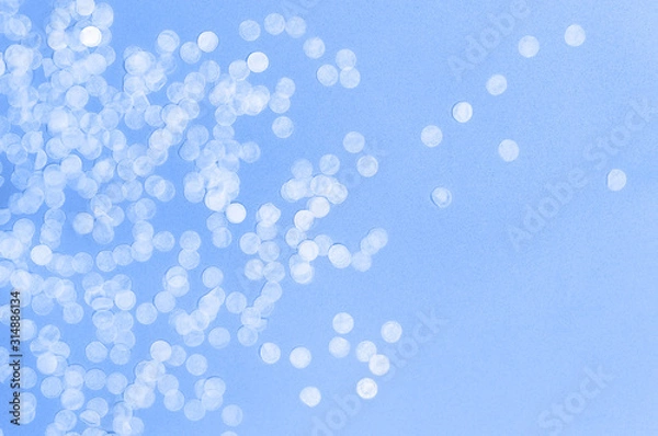 Fototapeta Flat lay paper round confetti on pastel blue background top view. Festive holiday background, concept of party, birthday, christmas or new year. Copyspace for text. Color of the year 2020 classic blue