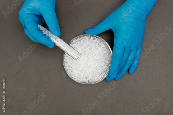 Fototapeta Plastic granules . Polyethylene pellets and hands with gloves. Quality control of plastic in the laboratory in production. BPA FREE.