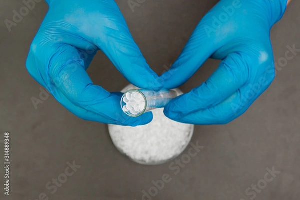 Fototapeta Plastic granules . Polyethylene pellets and hands with gloves. Quality control of plastic in the laboratory in production. BPA FREE.