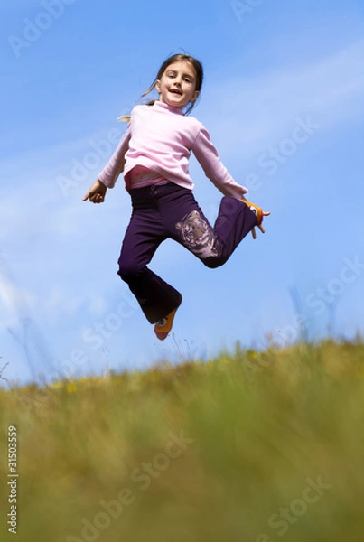 Obraz Girl jumping on the meadow, with blue sky and clouds in backgrou