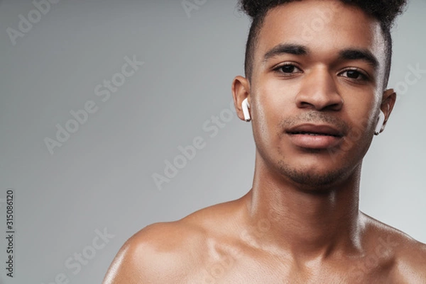 Fototapeta Photo closeup of shirtless african american man using earpods