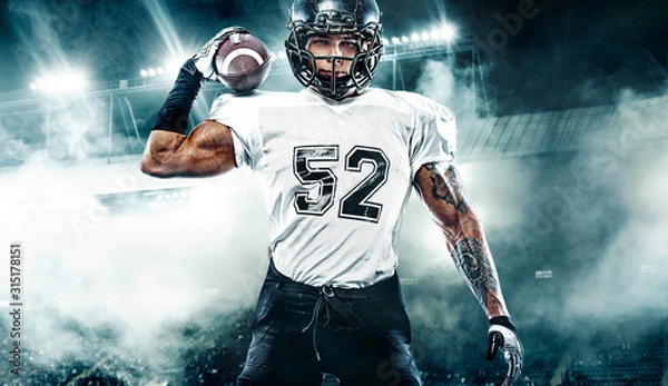 Fototapeta American football player. Sportsman with ball in helmet on stadium in action. Sport wallpaper. Team sports.