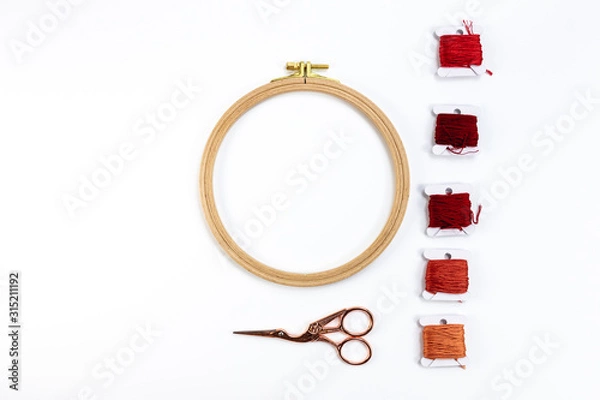 Obraz Embroidery accessories. Multicolored bundles of thread, scissors, sewing needles. White background ready for copywriting.