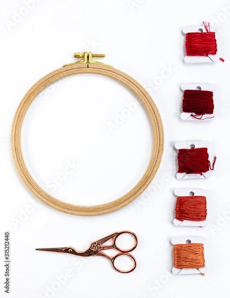 Obraz Embroidery accessories. Multicolored bundles of thread, scissors, sewing needles. White background ready for copywriting.