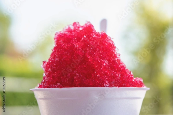 Fototapeta Shaved ice with sweet sala red syrup in foam cup.