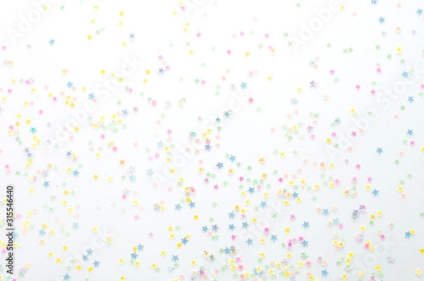 Fototapeta Gold stars confetti abstract pattern on a white background. Holiday concept, top view.
