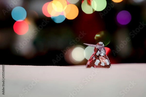 Fototapeta Chocolate is wrapped in an inverted cone shape. Against the bokeh background