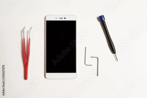 Fototapeta Repair of a cellular phone in the service with a special tool. Cellular phone repair tool on a white background.