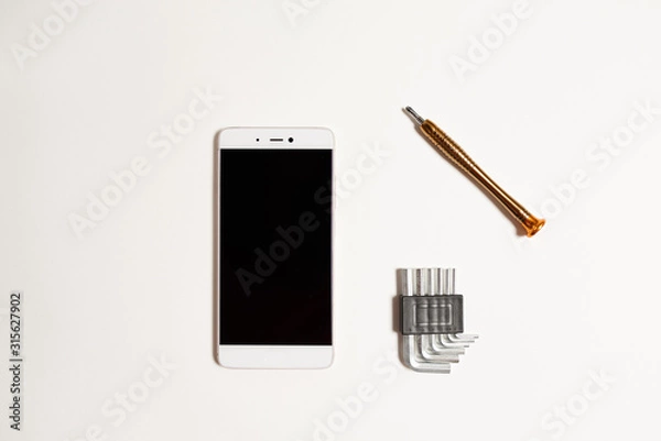 Fototapeta Repair of a cell phone in the service with a special tool. Cell phone repair tool on a white background.