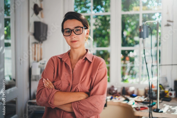 Obraz Portrait of young female entrepreneur working in her studio, young professional manager wearing casual clothes working in