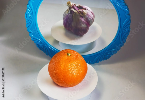Fototapeta Deceptive reflections. Mandarin with garlic.