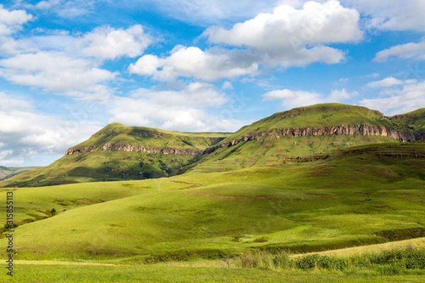 Fototapeta The green mountains of Maloti Drakensberg Park on a sunny day in summer with blue sky and some clouds, South Africa