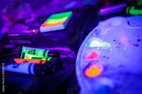 Obraz Multicolored UV fluorescent powder and paints on a palette