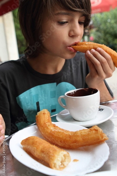 Obraz Junge mit Churros und Schokolade