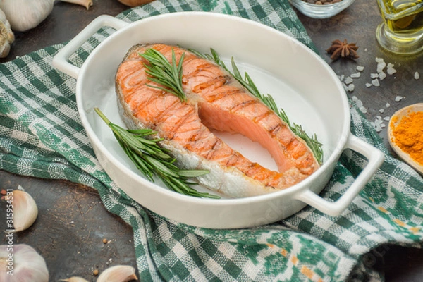 Fototapeta Grilled salmon filet steak with aromatic herbs, spices and vegetables. Seafood. Cooking concept. Culinary background. Table background menu. Copy space
