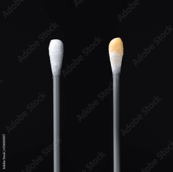 Fototapeta Before and after using the ear stick. Cotton sticks isolated on black background