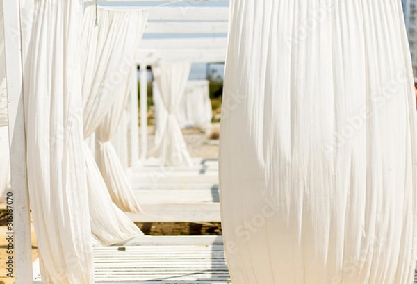 Obraz Lounger bed with white curtins on the beach for a relaxing getaway.